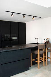 Schwarzer Strahler FAVORI TRACK von Lucide Leuchten, montiert an der Decke einer modernen Küche, aus seitlicher Perspektive fotografiert.