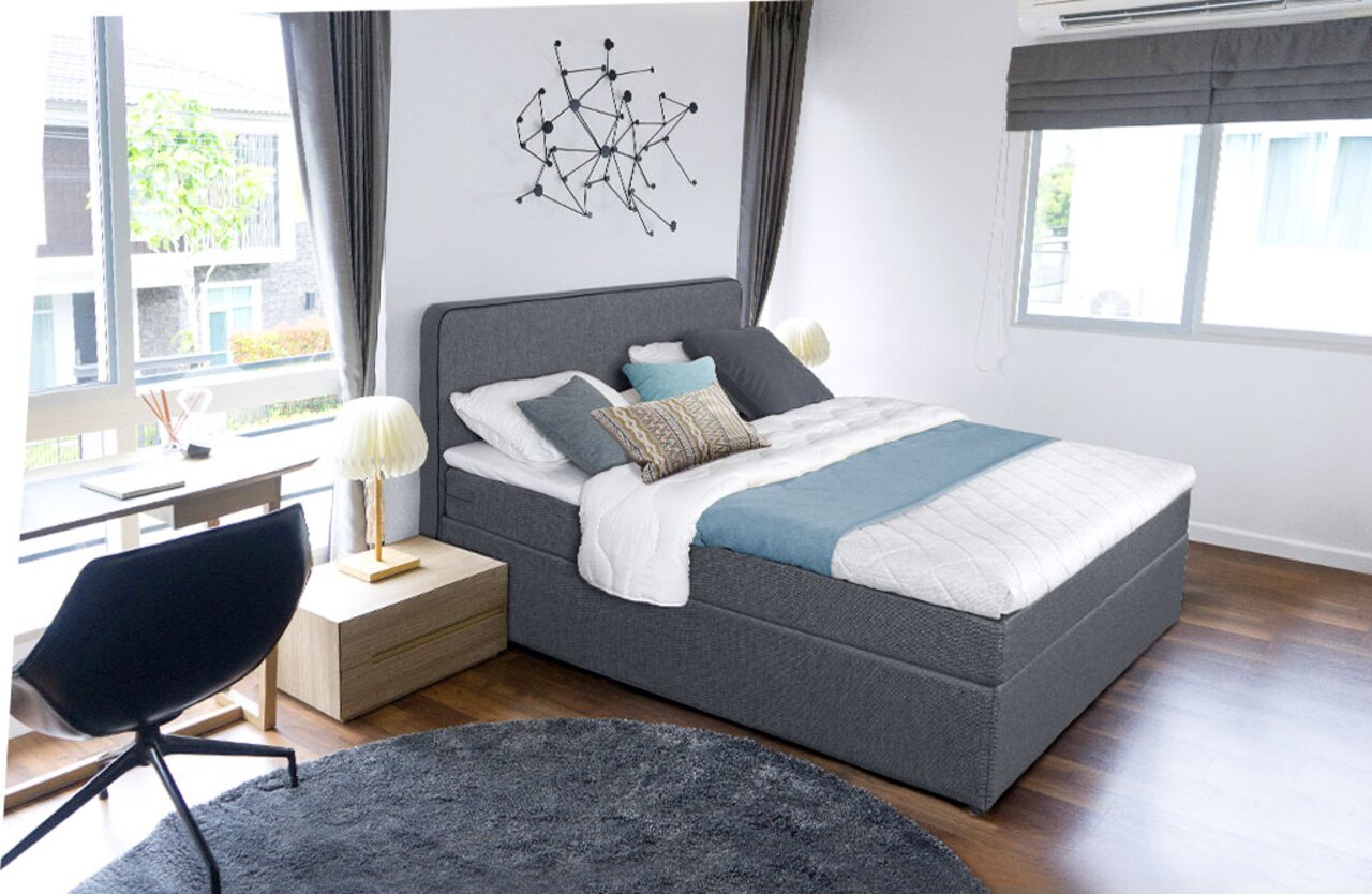 Graues Boxbett in modernem Schlafzimmer, seitliche Perspektive