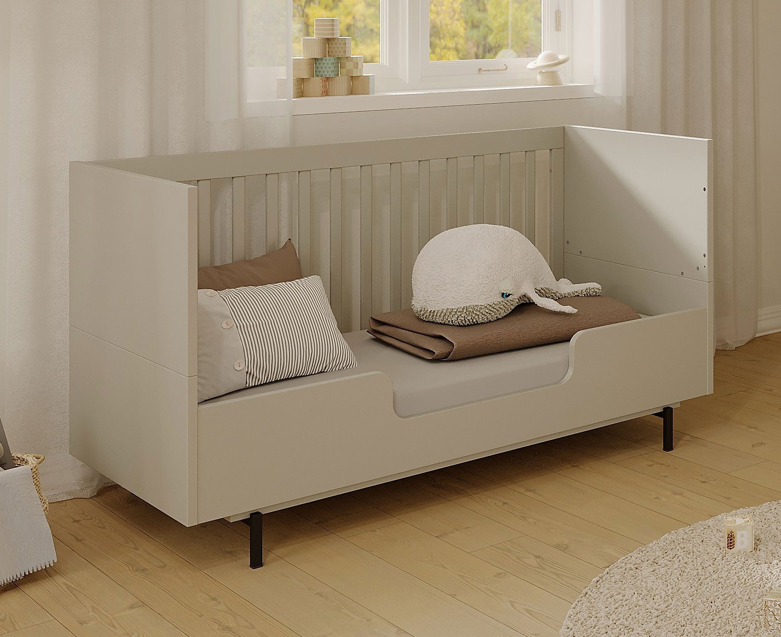 Kinderbett mit hoher Umbauseite, seitliche Perspektive, dekoriert mit Kissen und Kuscheltier.