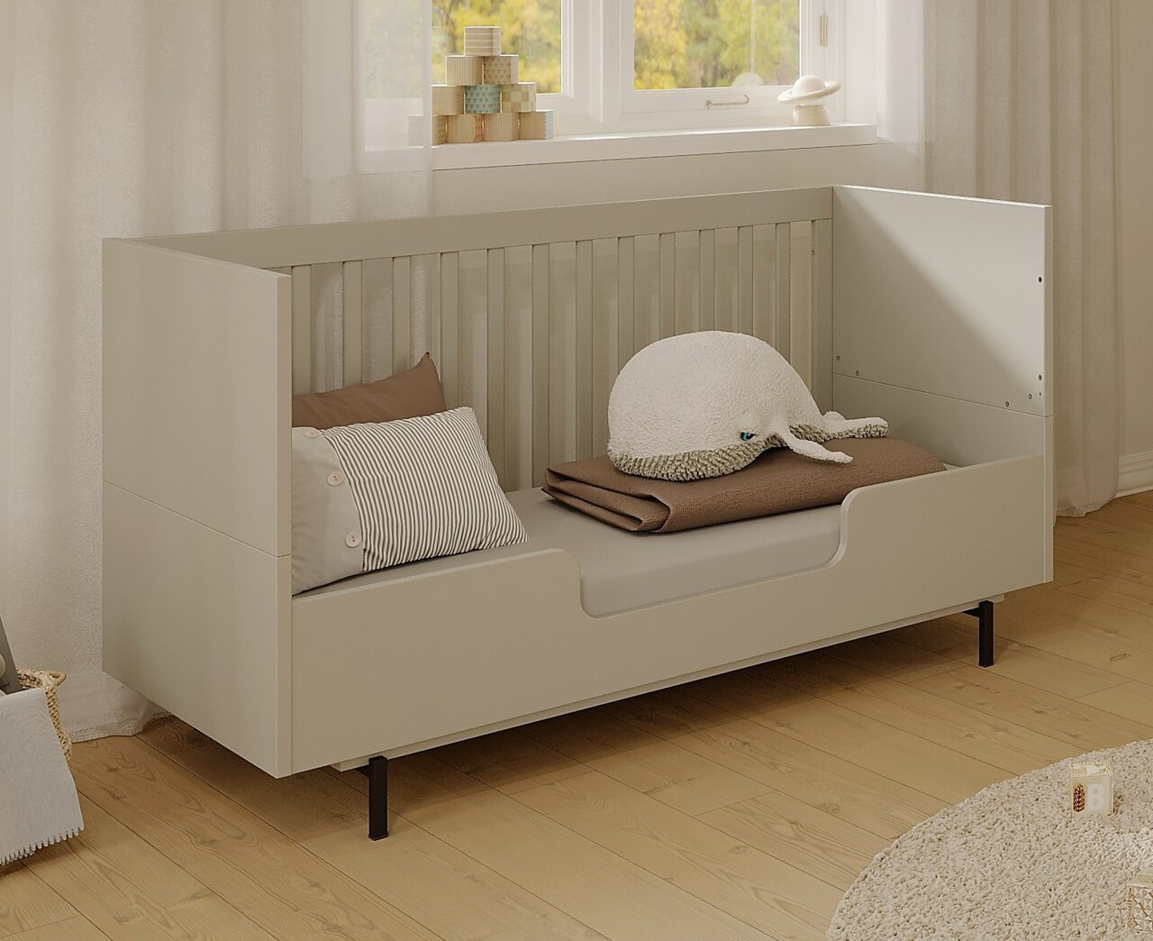 Germania Hohe Umbauseite TOMINO Kinderbett mit hoher Umbauseite, seitliche Perspektive, dekoriert mit Kissen und Kuscheltier.