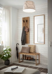 Moderner Eingangsbereich mit Garderobenpaneel, Spiegel und Garderobenbank aus Holz. Perspektive von vorne.