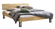 Modernes Doppelbett aus hellem Holz mit schlichtem Kopfteil und Metallfüßen, bezogen mit grauer Bettwäsche und Dekokissen, gezeigt in schräger Vorderansicht