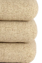 Nahaufnahme eines beigen Sitzpuffs mit strukturierter Oberfläche, von der Seite betrachtet.