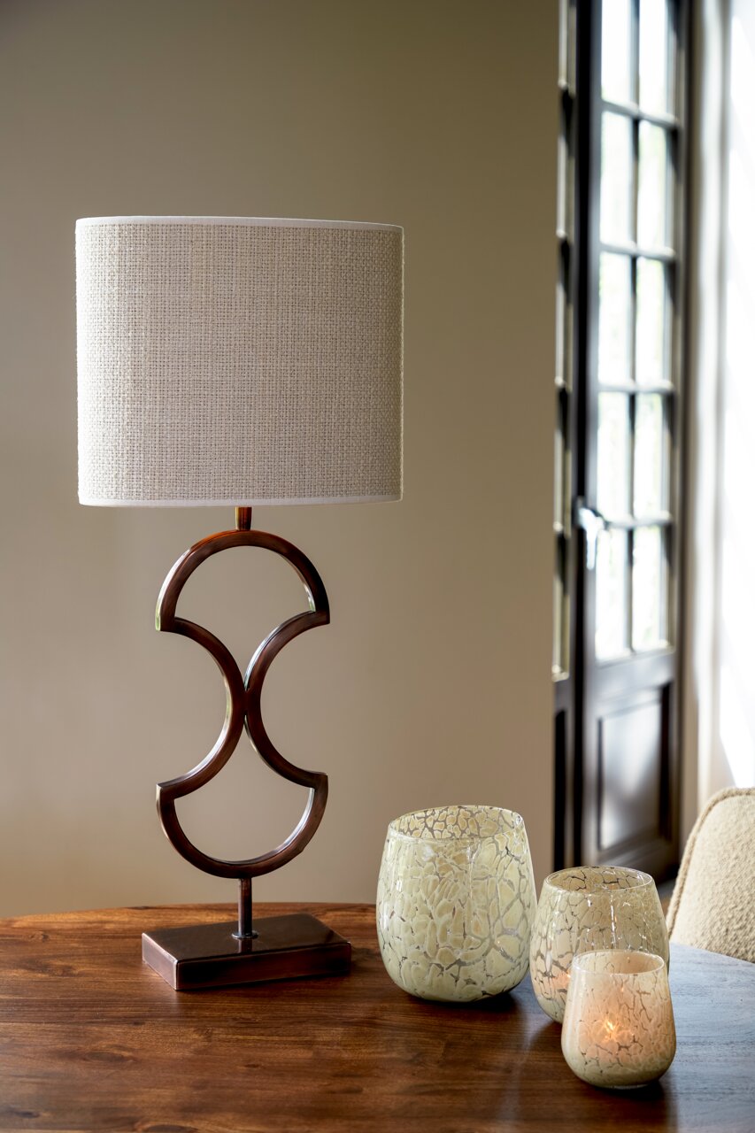 Light&Living Lampenschirm SAISON Moderner Tischlampenschirm in ovaler Form mit elegantem, geschwungenem Metallfuß, frontal auf einem Holztisch platziert.