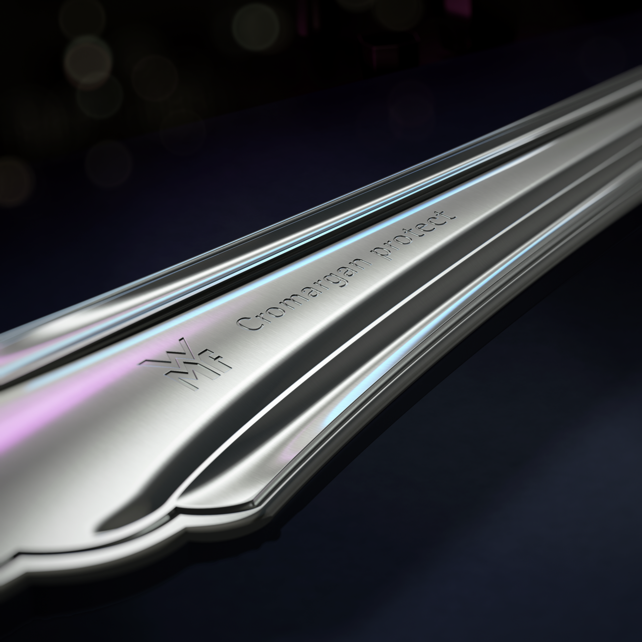 Nahaufnahme eines glänzenden Besteckteils mit Gravur 'Cromargan protect' und WMF-Logo, seitliche Perspektive.