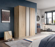 Moderner Kleiderschrank in heller Holzoptik mit mittlerer Spiegeltür im Schlafzimmer, frontale Ansicht leicht von links.