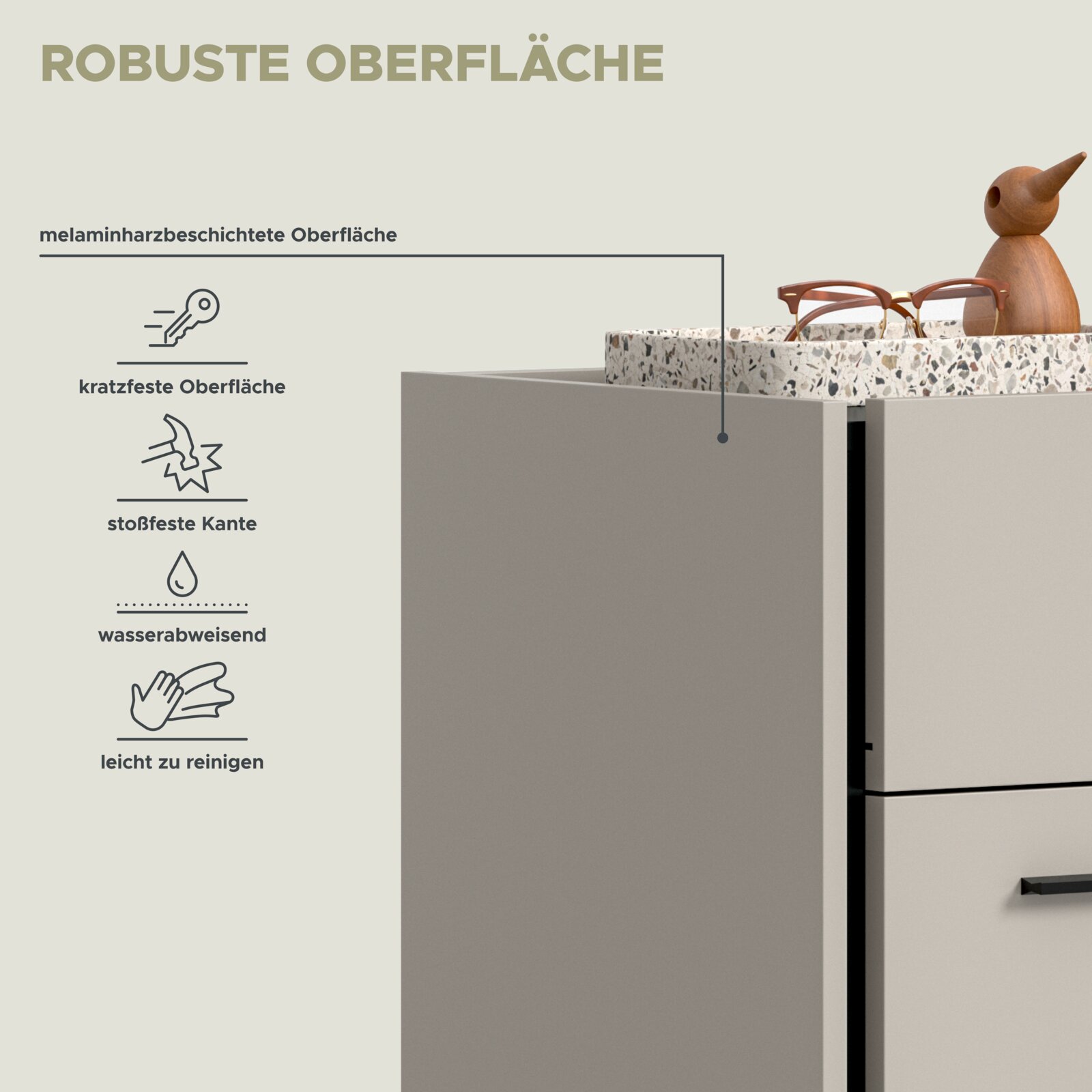 Nahaufnahme eines hellgrauen Möbelstücks mit offener Schublade und melaminharzbeschichteter, robuster Oberfläche; perspektivisch aus leicht seitlicher Frontansicht von oben, mit Terrazzo-Einsatz und darauf liegender Brille.