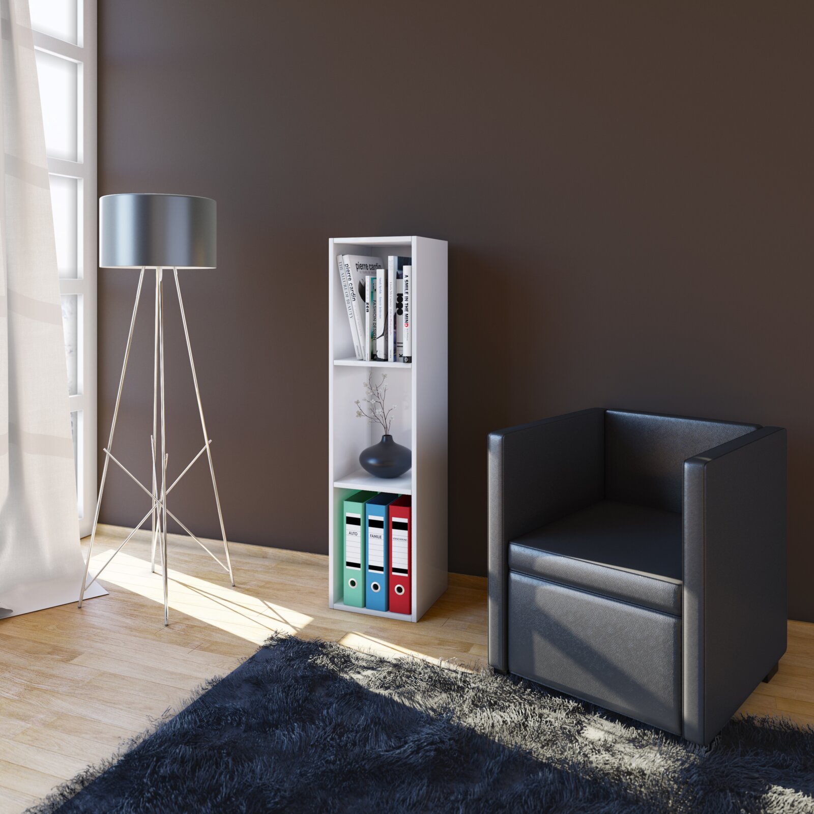 Weißes, schmales Standregal mit drei Fächern, oben Bücher, mittig Vase, unten bunte Aktenordner, in Wohnzimmerecke neben Stehlampe und schwarzem Sessel, perspektivisch leicht von links vorne auf Augenhöhe aufgenommen
