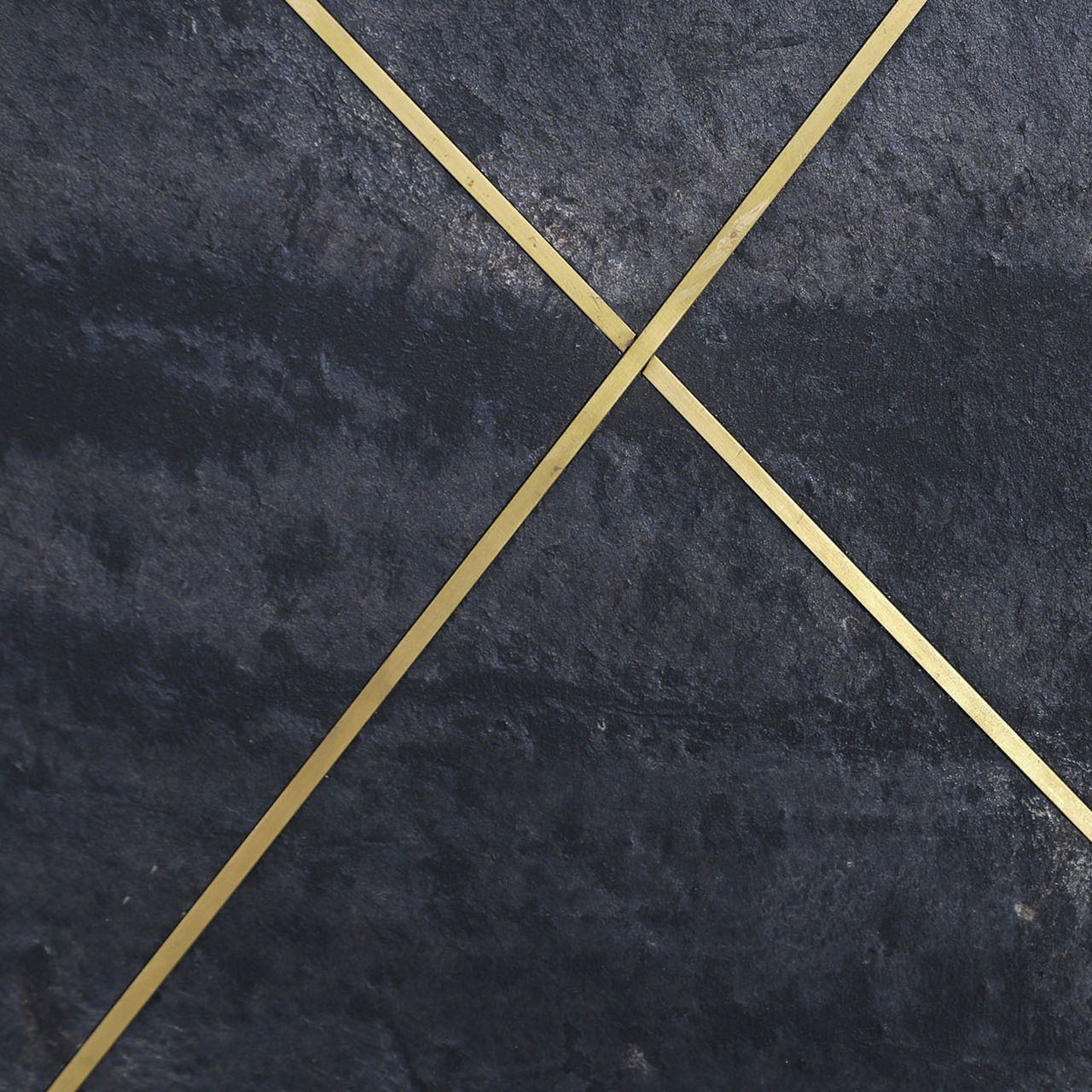 Nahaufnahme eines Sideboards mit dunkler Steinoptik und goldenen diagonalen Linien.