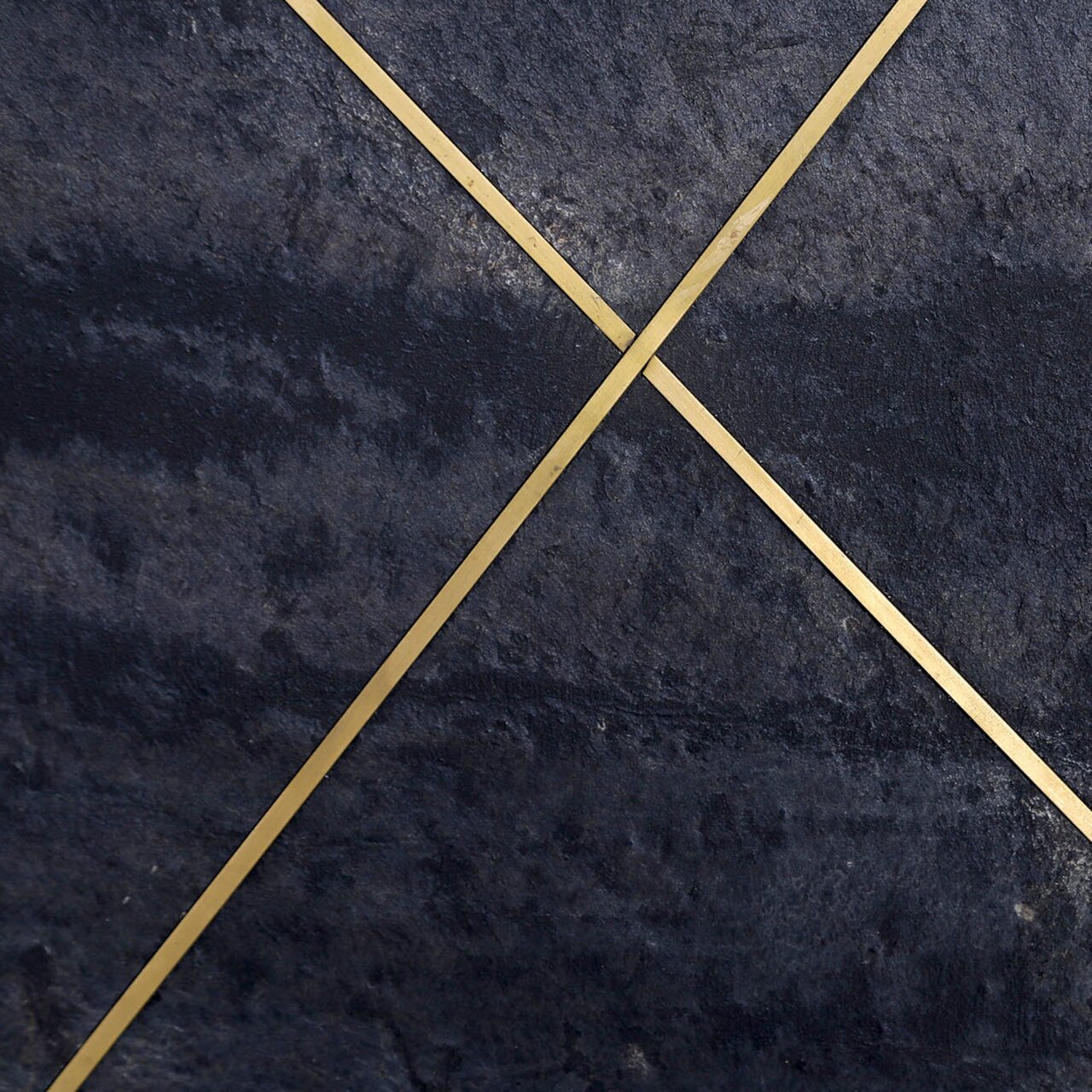 Nahaufnahme eines Sideboards mit dunkler Steinoptik und goldenen diagonalen Linien.