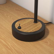 Nahaufnahme der Basis einer Tischleuchte mit schwarzem Rand und Holzoptik, seitliche Perspektive.