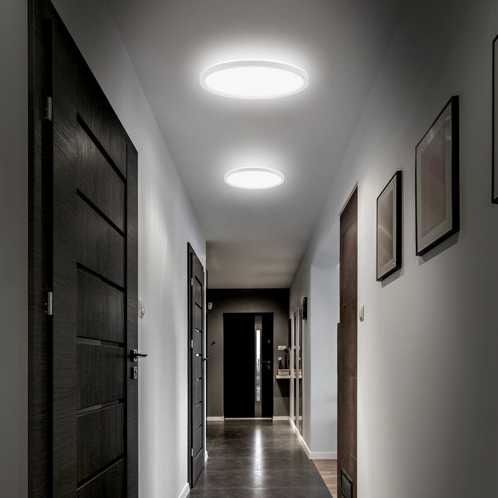 Moderne ronde LED-plafondlampen die een gang verlichten, gezien in perspectief van onderaf richting het einde van de hal