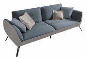 Modernes graues Sofa mit zwei Sitzplätzen, abgebildet aus einer leicht schrägen Perspektive von oben, mit mehreren Kissen in verschiedenen Grautönen.