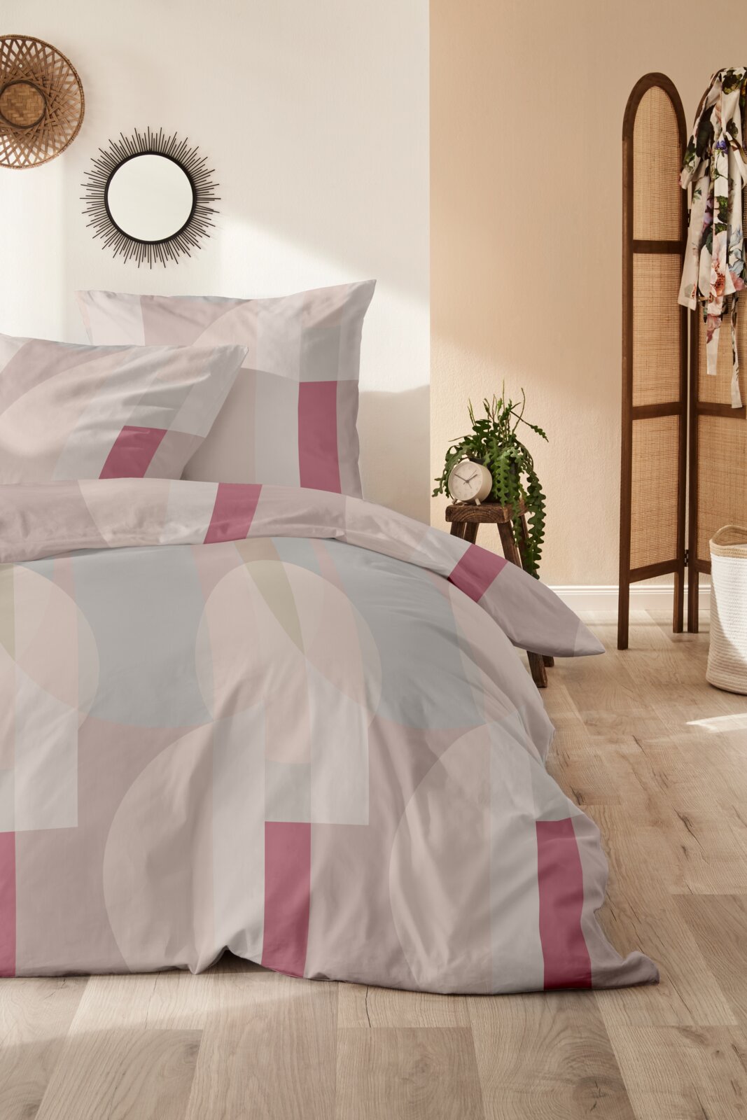 Bettwäsche-Set 155x220cm mit geometrischem Muster in Rosa und Weiß, fotografiert in einem stilvoll eingerichteten Schlafzimmer.