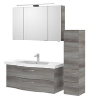 Moderner Badblock mit grauer Holzoptik, bestehend aus einem Waschbeckenunterschrank mit zwei Schubladen, einem hohen Seitenschrank mit drei Schubladen und einem Spiegelschrank mit Beleuchtung, frontal abgebildet.