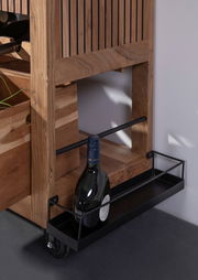 Nahaufnahme eines Servierwagens aus Holz mit einer Flasche Wein in einem unteren Metallregal, seitliche Perspektive.