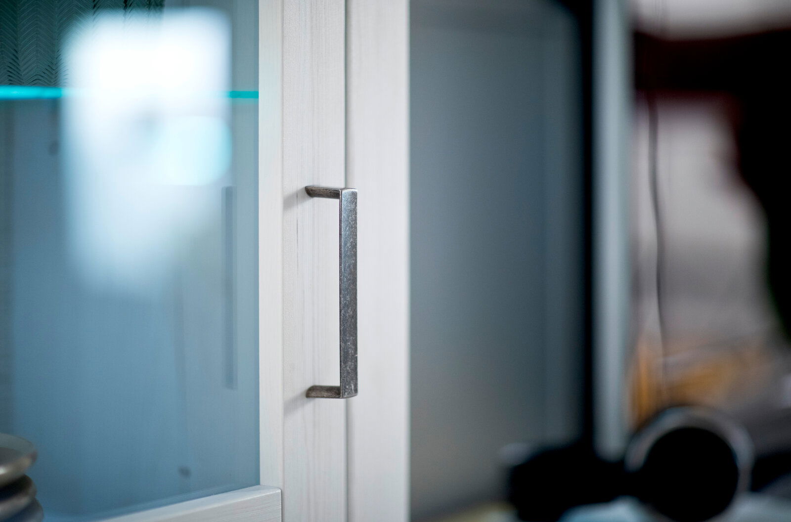 Landscape LED-Bandbeleuchtung BREGENZ Nahaufnahme eines Schrankgriffs an einer Glastür mit Holzrahmen, seitliche Perspektive