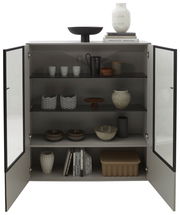 Geöffnetes Highboard mit dekorativen Objekten und Büchern, Frontalansicht