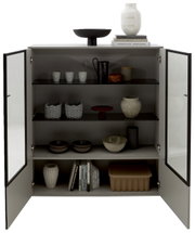 Geöffnetes Highboard mit dekorativen Objekten und Büchern, Frontalansicht