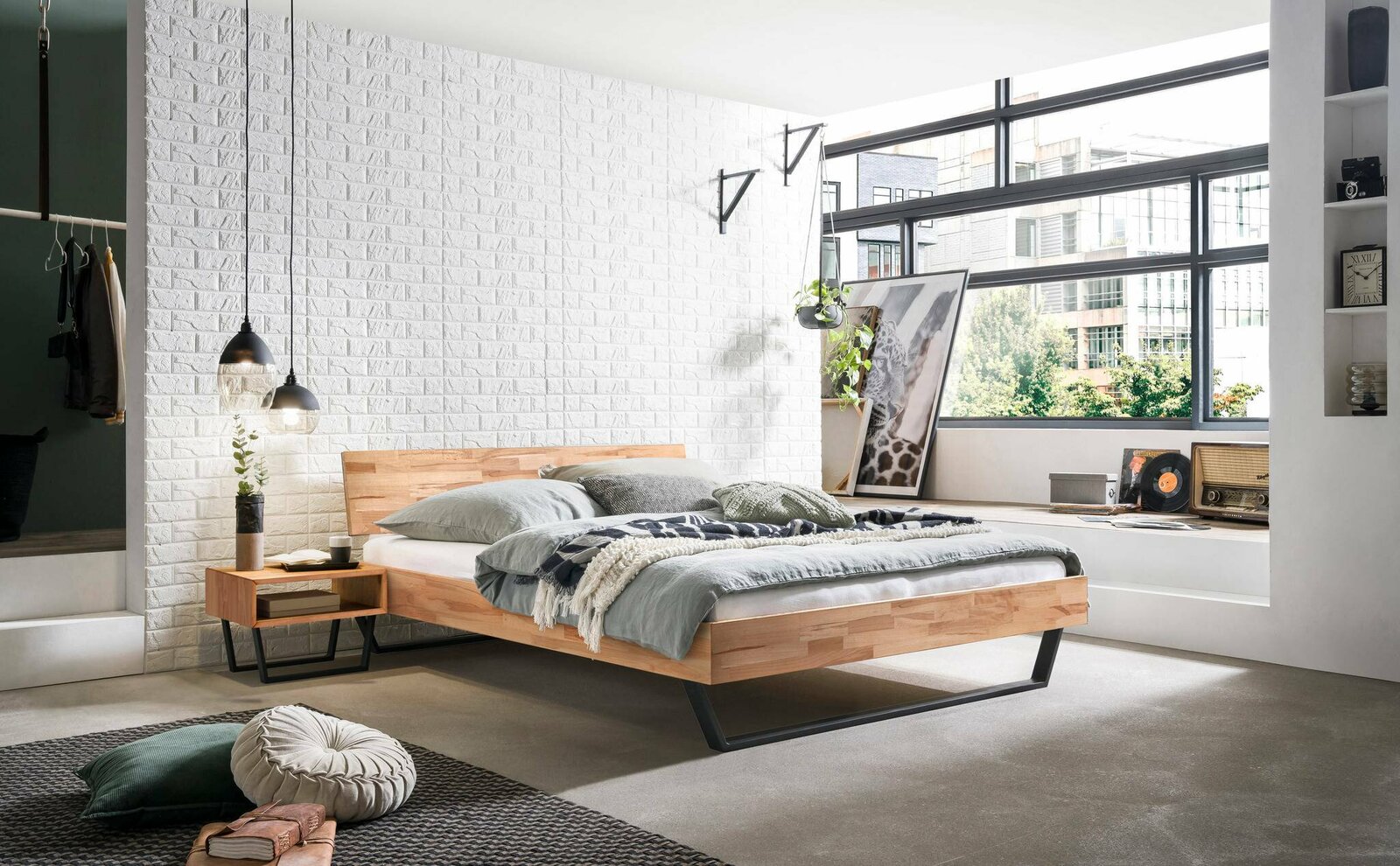 Modernes Schlafzimmer mit einem Bettgestell aus Holz und Metall, seitliche Perspektive. Das Zimmer ist hell und stilvoll eingerichtet mit großen Fenstern, die viel Tageslicht hereinlassen.