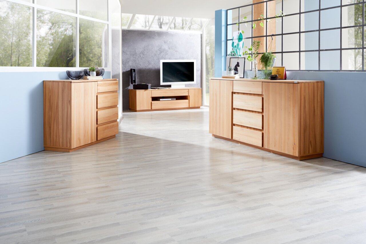 Helles Holz-Sideboard und TV-Lowboard in modernem Wohnzimmer, seitliche Perspektive