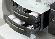 Moderner Badblock mit zwei geöffneten Schubladen, gefüllt mit Handtüchern und Pflegeprodukten, aus der Vogelperspektive fotografiert.