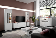 Modernes Wohnzimmer mit Highboard-Set von Musterring, bestehend aus einem weißen Highboard, TV-Schrank und Couchtisch, in einer stilvollen, hellen Umgebung mit großen Fenstern und Pflanzen. Perspektive: Frontalansicht.