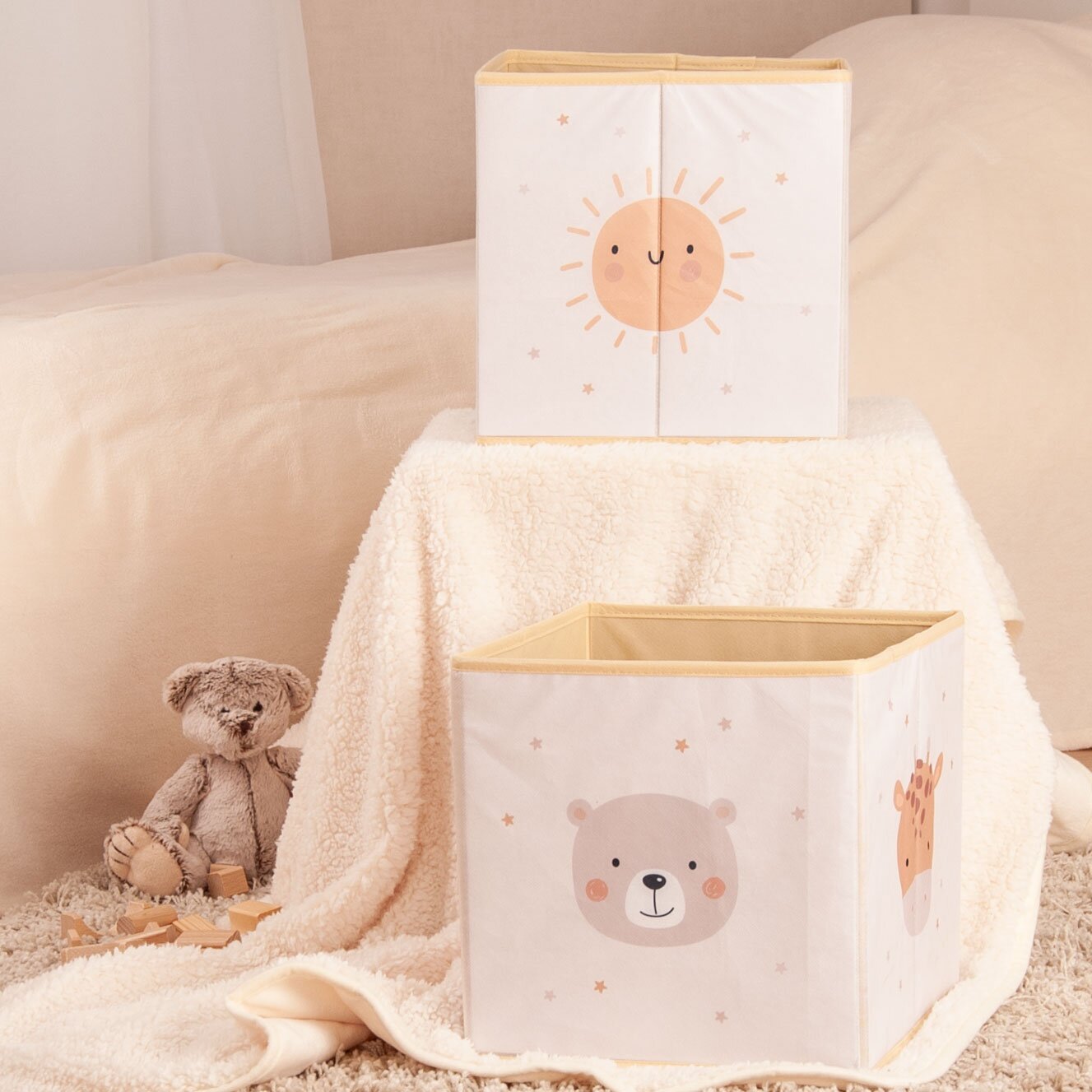 Herding Aufbewahrungsbox LITTLE FRIENDS Zwei Aufbewahrungsboxen mit niedlichen Tiermotiven, eine mit einem Sonnenmotiv und die andere mit einem Bärenmotiv, auf einem weichen, beigen Hintergrund. Perspektive von vorne.