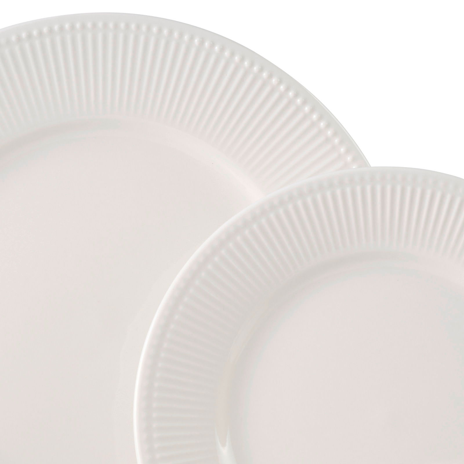 Nahaufnahme von zwei weißen Tellern mit geriffeltem Rand, übereinander gestapelt.