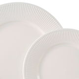 Nahaufnahme von zwei weißen Tellern mit geriffeltem Rand, übereinander gestapelt.