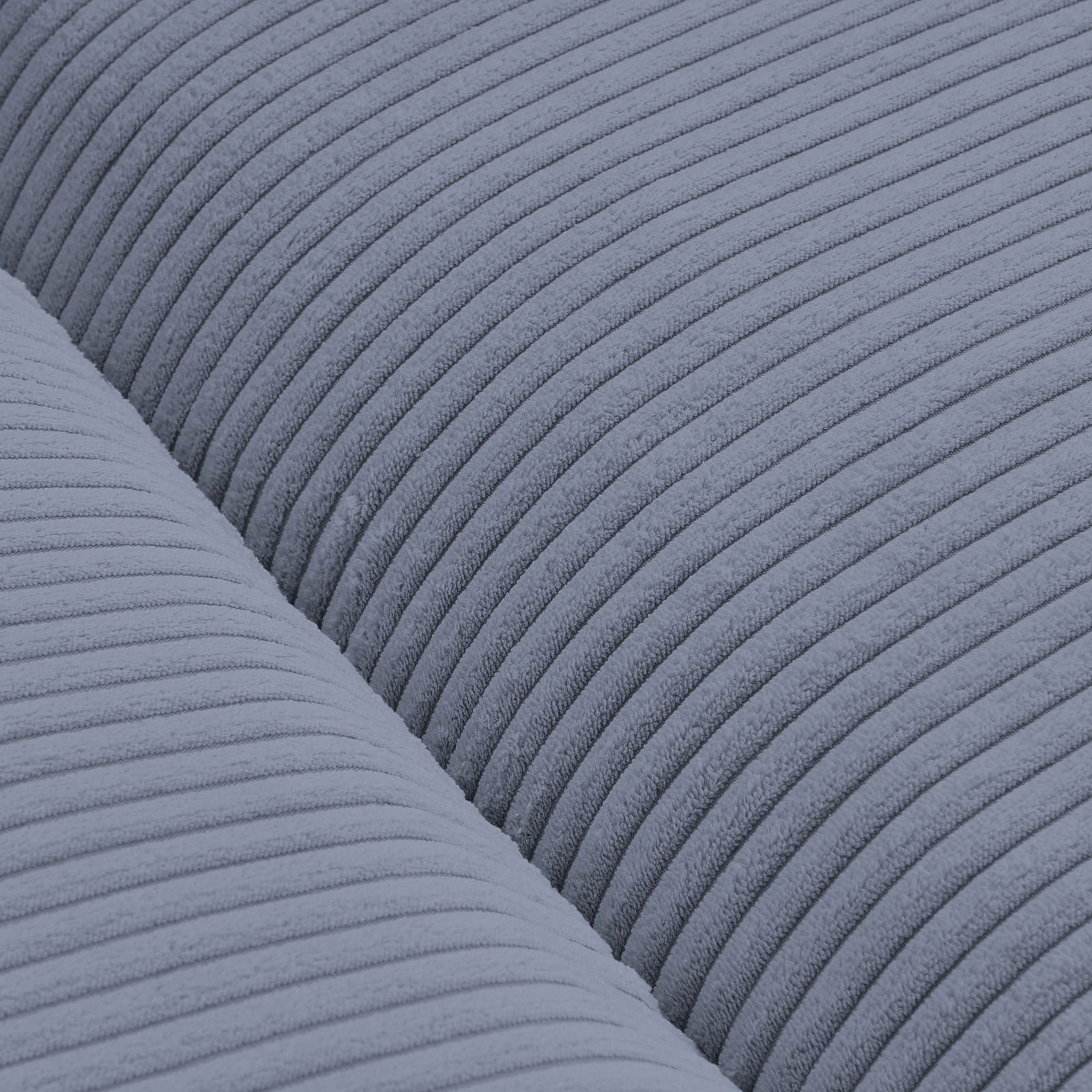 Nahaufnahme eines blauen, gerippten Stoffes eines Big-Sofas in Draufsicht.