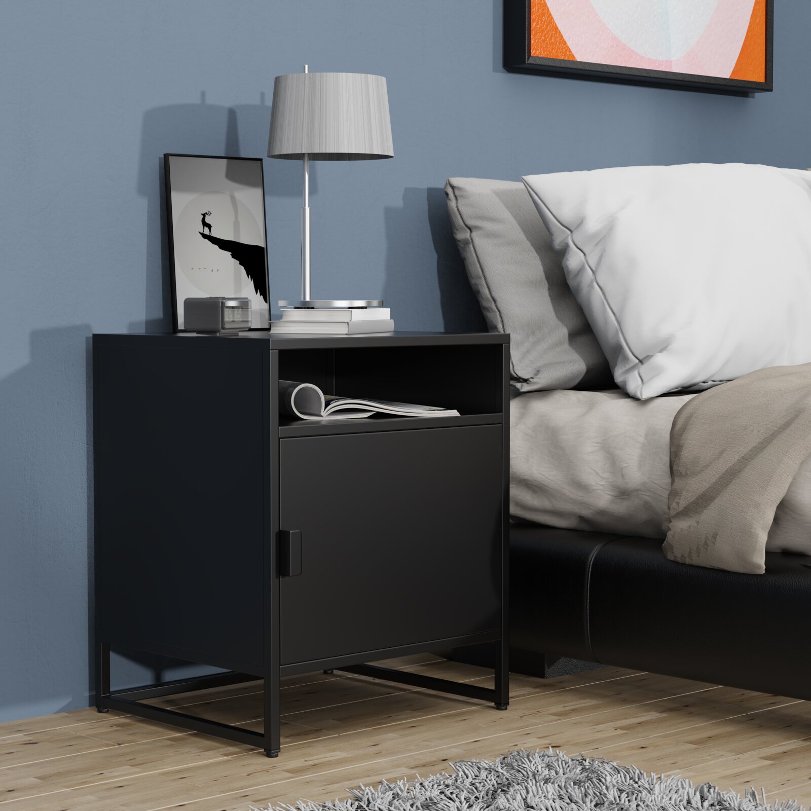 Schwarzer, moderner Nachttisch mit Metallgestell, offener Ablage und Schranktür neben einem Bett, darauf Lampe und Deko Perspektive: frontale Seitenansicht auf Augenhöhe.