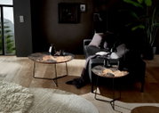 Zwei Couchtische mit floralem Muster in einem modernen Wohnzimmer, seitliche Perspektive.