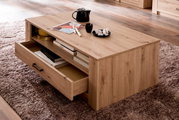 Moderner Couchtisch aus Holz mit Schubladen, von schräg oben fotografiert, auf einem Teppich stehend.