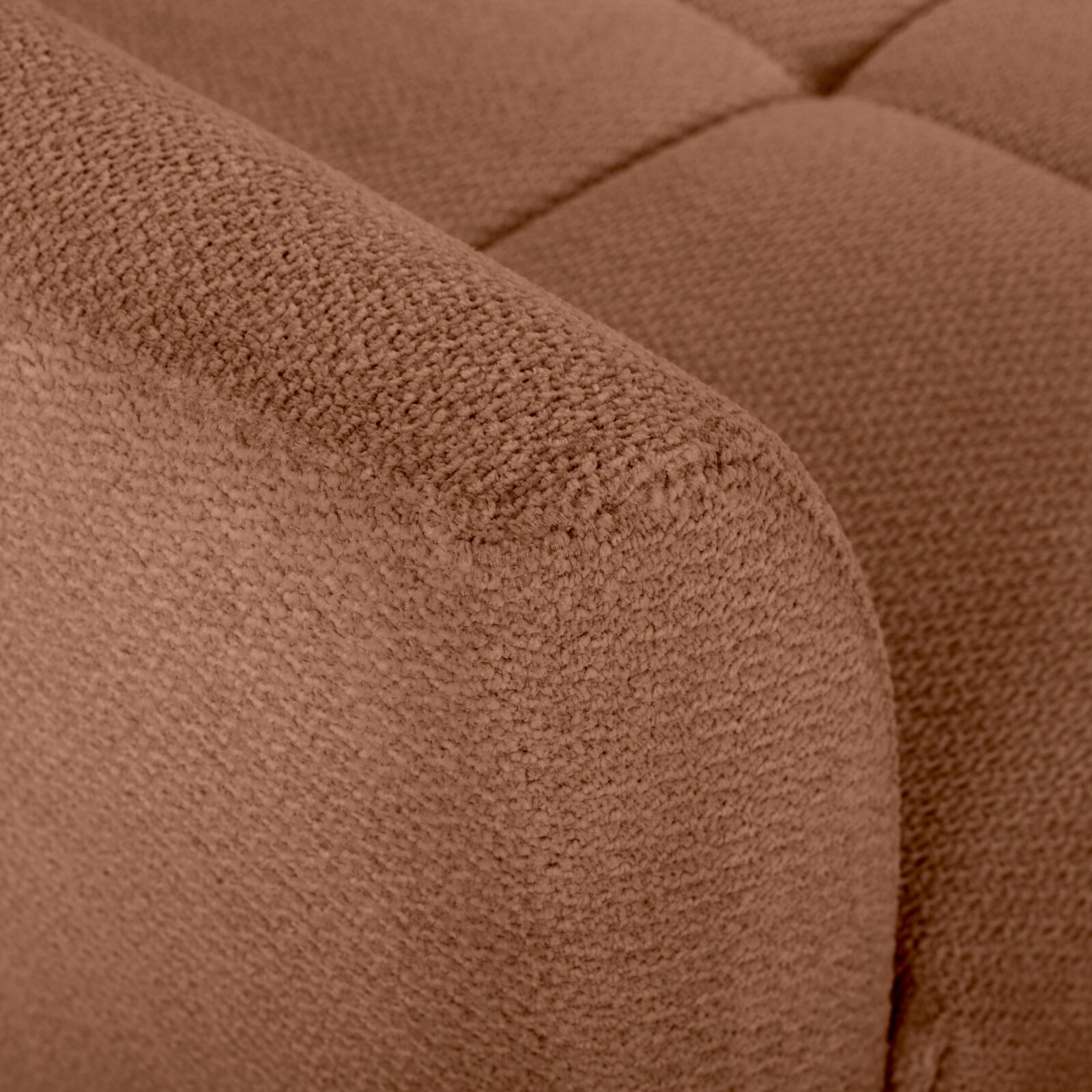 Nahaufnahme eines braunen, strukturierten Bouclé-Polsterstoffs an der Armlehne und Sitzfläche eines Sofas, Perspektive: Detailaufnahme von schräg oben.