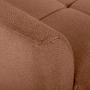 Nahaufnahme eines braunen, strukturierten Bouclé-Polsterstoffs an der Armlehne und Sitzfläche eines Sofas, Perspektive: Detailaufnahme von schräg oben.