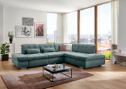 Großes türkisfarbenes, gepolstertes Ecksofa mit rechter Ottomane und gesteppten Sitzflächen im modernen Wohnzimmer vor bodentiefen Fenstern, Perspektive: frontal leicht von links.