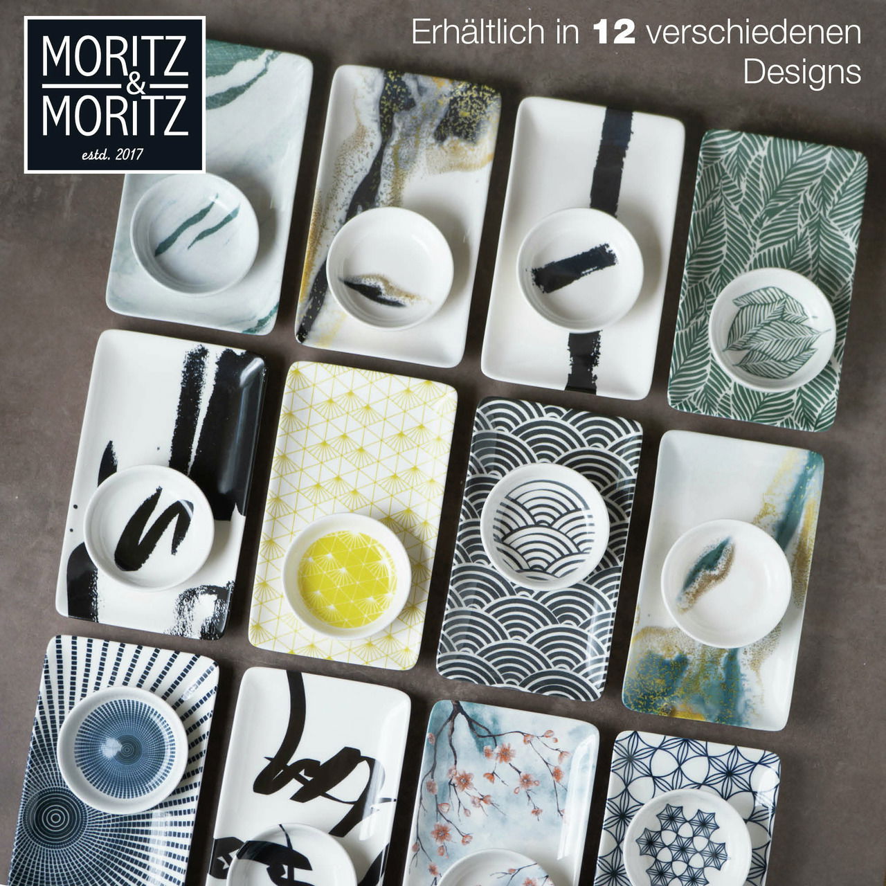 Vogelperspektive auf ein Sushi-Set mit 10 rechteckigen Tellern und passenden Schälchen, verziert mit verschiedenen blauen und schwarzen Mustern sowie floralen Designs.