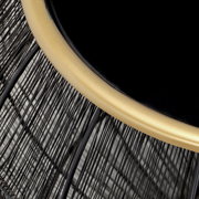 Nahaufnahme eines Beistelltisches mit schwarzer Tischplatte und goldfarbenem Rand, Drahtgestell aus schwarzem Metall, von oben betrachtet.