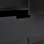 Nahaufnahme eines modernen, schwarzen Sideboards mit offener Schublade, seitliche Perspektive
