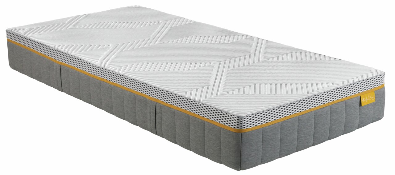 Seitliche Ansicht einer irisette Matratze 90x200 BODY&SOUL mit gestepptem weißen Bezug und grauem Rand.