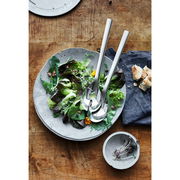 Salatbesteck NUOVA 30cm aus Edelstahl, auf einem Salatteller mit frischem Salat, von oben fotografiert.