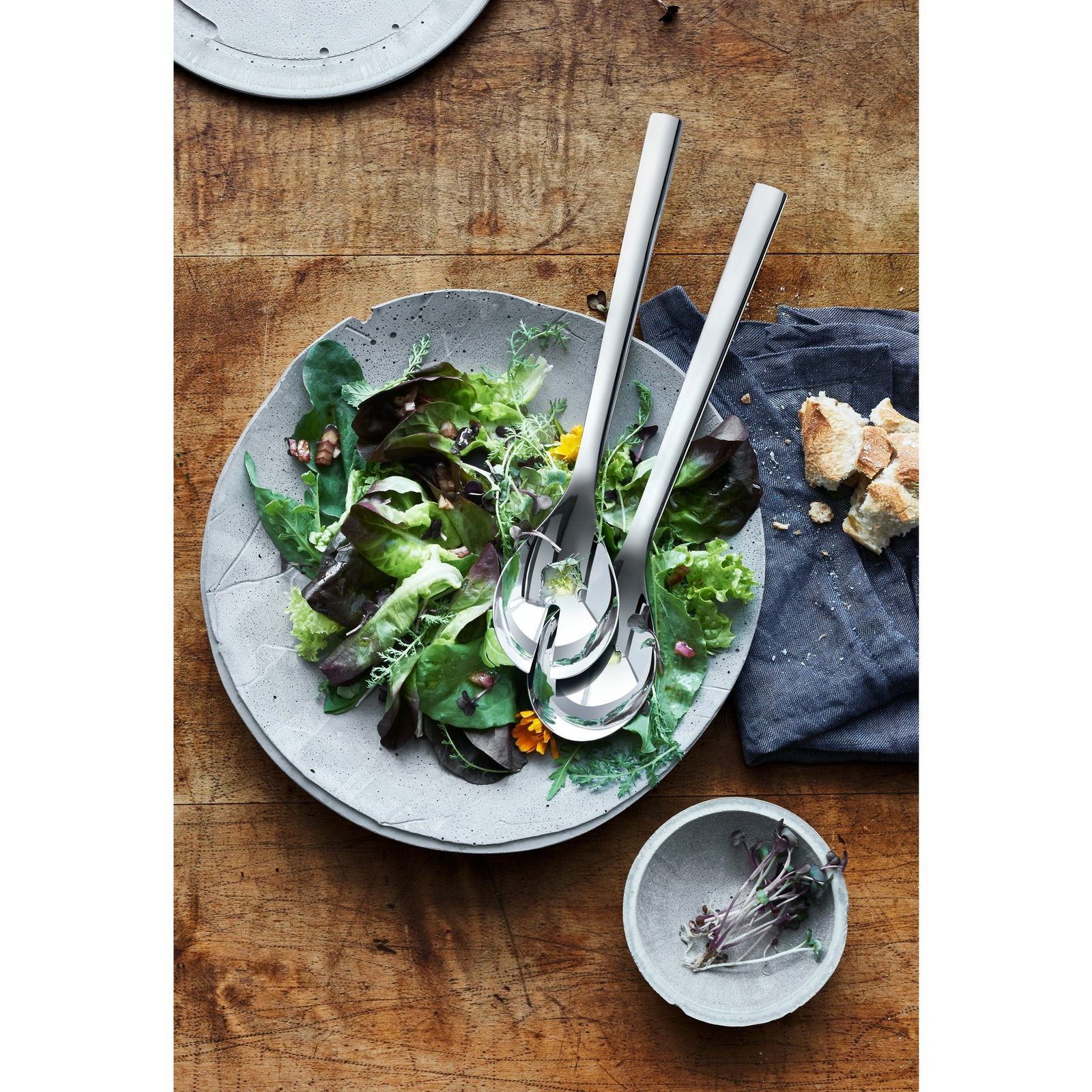 Salatbesteck NUOVA 30cm aus Edelstahl, auf einem Salatteller mit frischem Salat, von oben fotografiert.