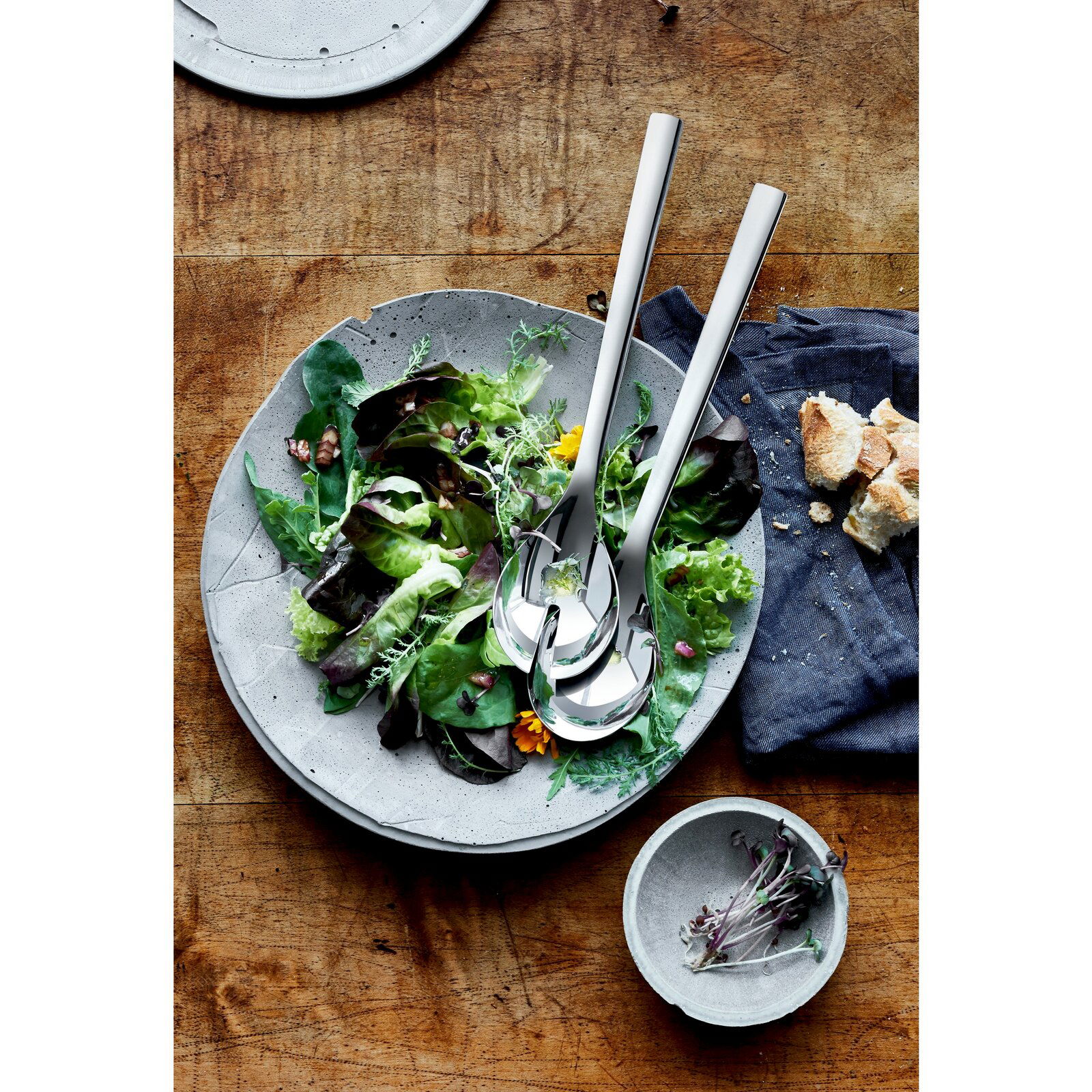 WMF Salatbesteck 30cm NUOVA Salatbesteck NUOVA 30cm aus Edelstahl, auf einem Salatteller mit frischem Salat, von oben fotografiert.