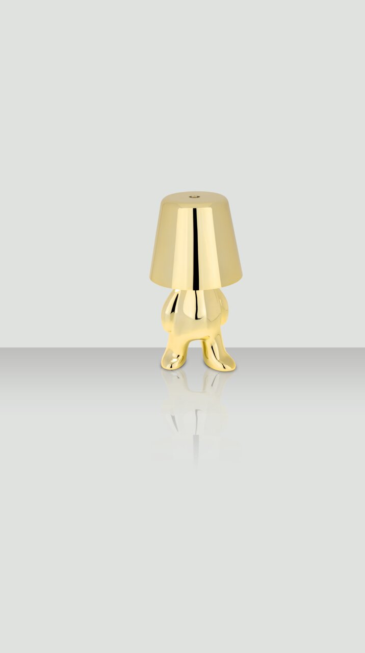 Goldene Akku-Tischleuchte in Form einer stilisierten Figur, frontal abgebildet.