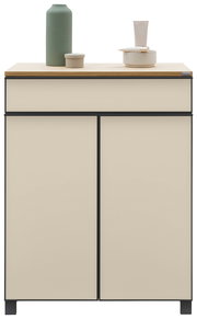 Moderner Schuhschrank in Cremefarbe mit schwarzem Rahmen, dekoriert mit einer grünen Vase und Keramikschalen auf der Oberseite, Frontalansicht.