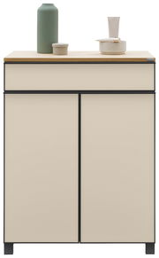 Moderner Schuhschrank in Cremefarbe mit schwarzem Rahmen, dekoriert mit einer grünen Vase und Keramikschalen auf der Oberseite, Frontalansicht.