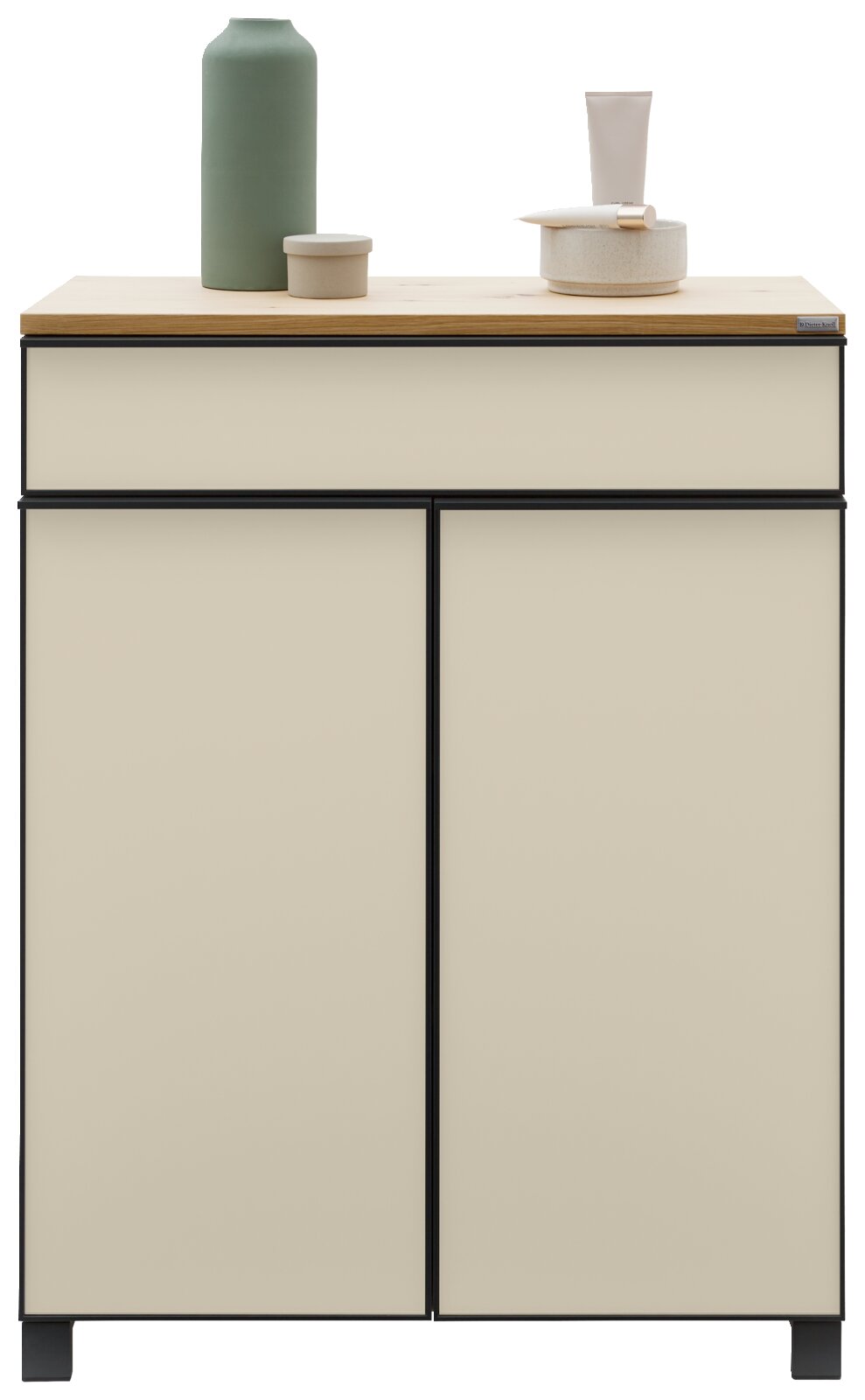 Moderne schoenenkast in crèmekleur met een zwart frame, versierd met een groene vaas en keramische schaaltjes op het blad, gezien van voren.