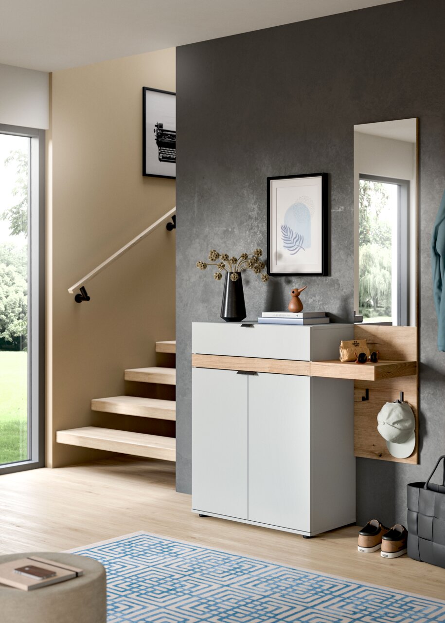 Moderner Flur mit weißem Schuhschrank und Holzablage, Wandpaneel mit Haken und Spiegel, dekoriert mit Vase und Büchern, fotografiert in frontaler leicht seitlicher Perspektive.