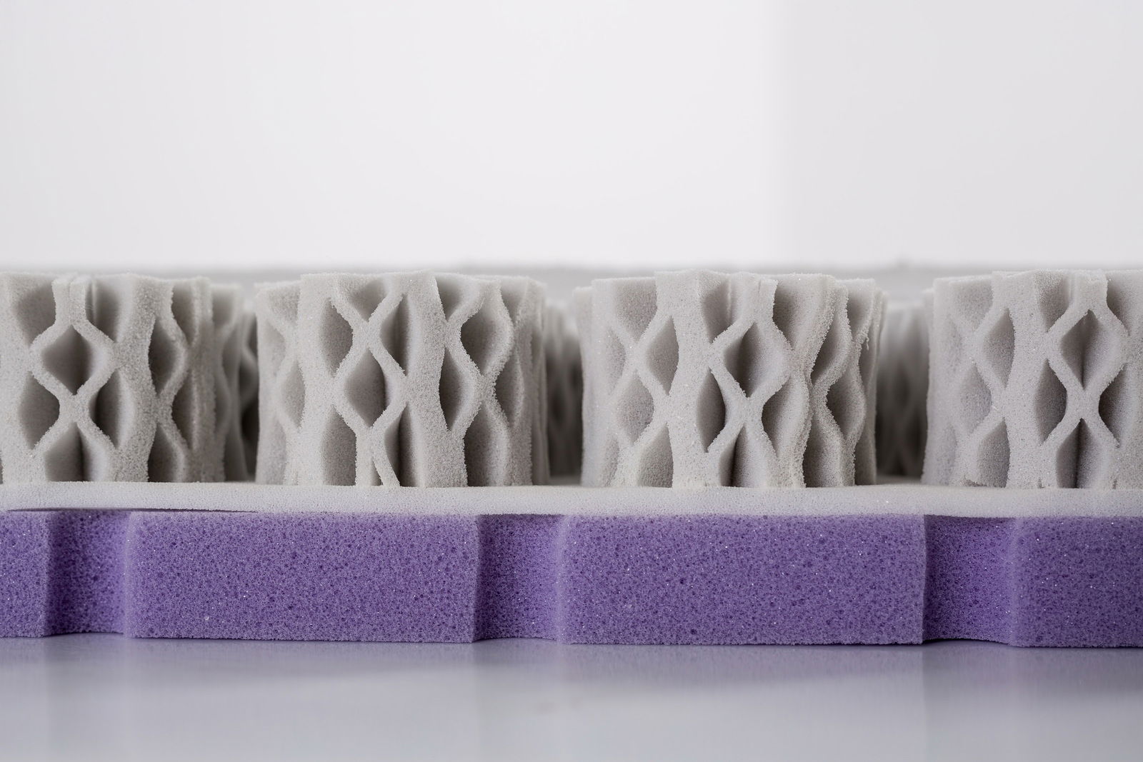 Nahaufnahme einer Matratzenstruktur mit lila und grauen Schaumstoffschichten, seitliche Perspektive